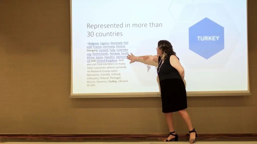 Dr. Menekşe Ahbab sunum ekranındaki üye ülkeler listesini anlatırken